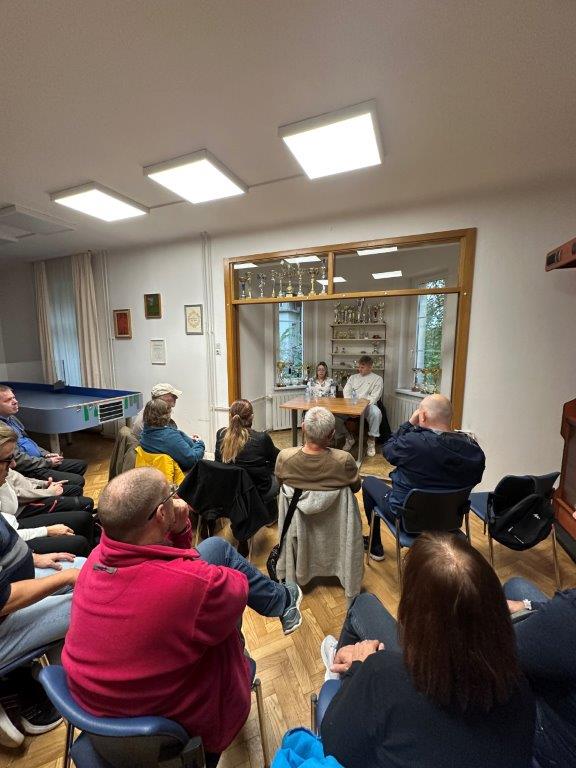 Slika prikazuje polno sejno dvorano in naša dva gosta v ozadju.