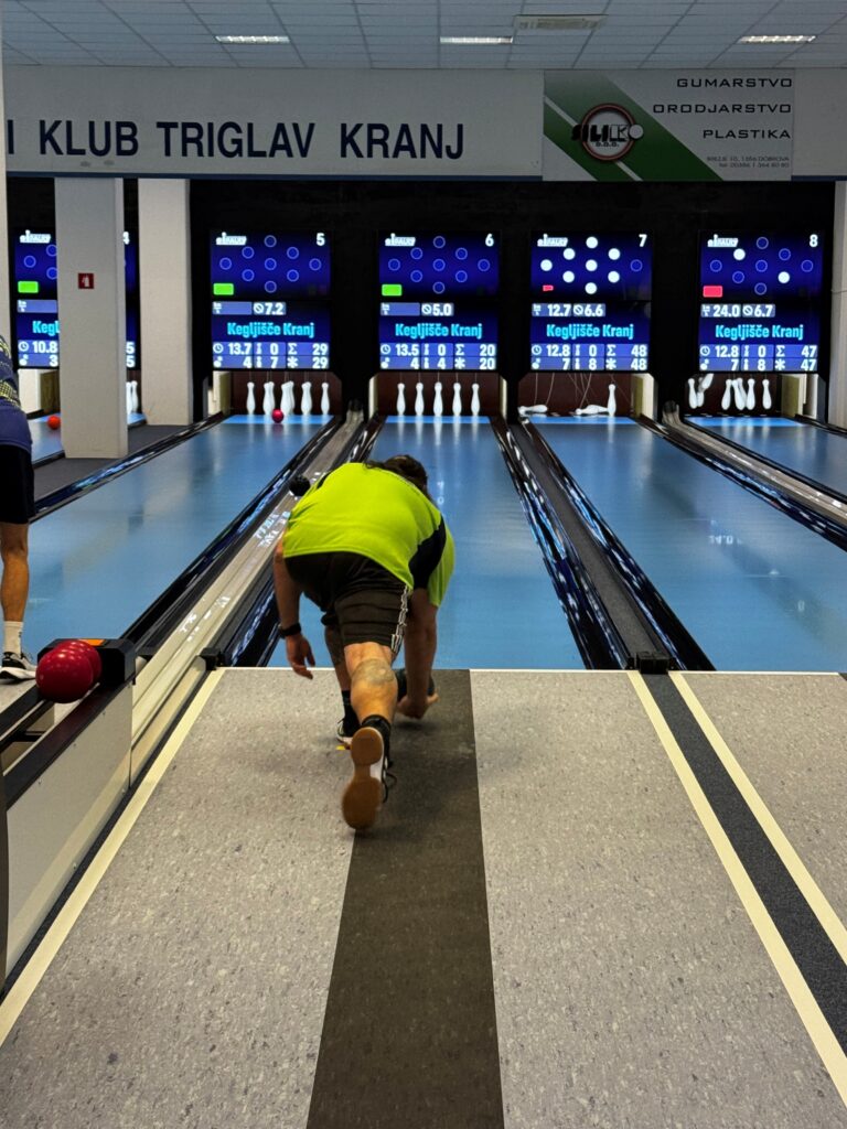 Slika prikazuje tekmovalca MDSS Ljubljana, kako vrže kroglo za kegljanje.