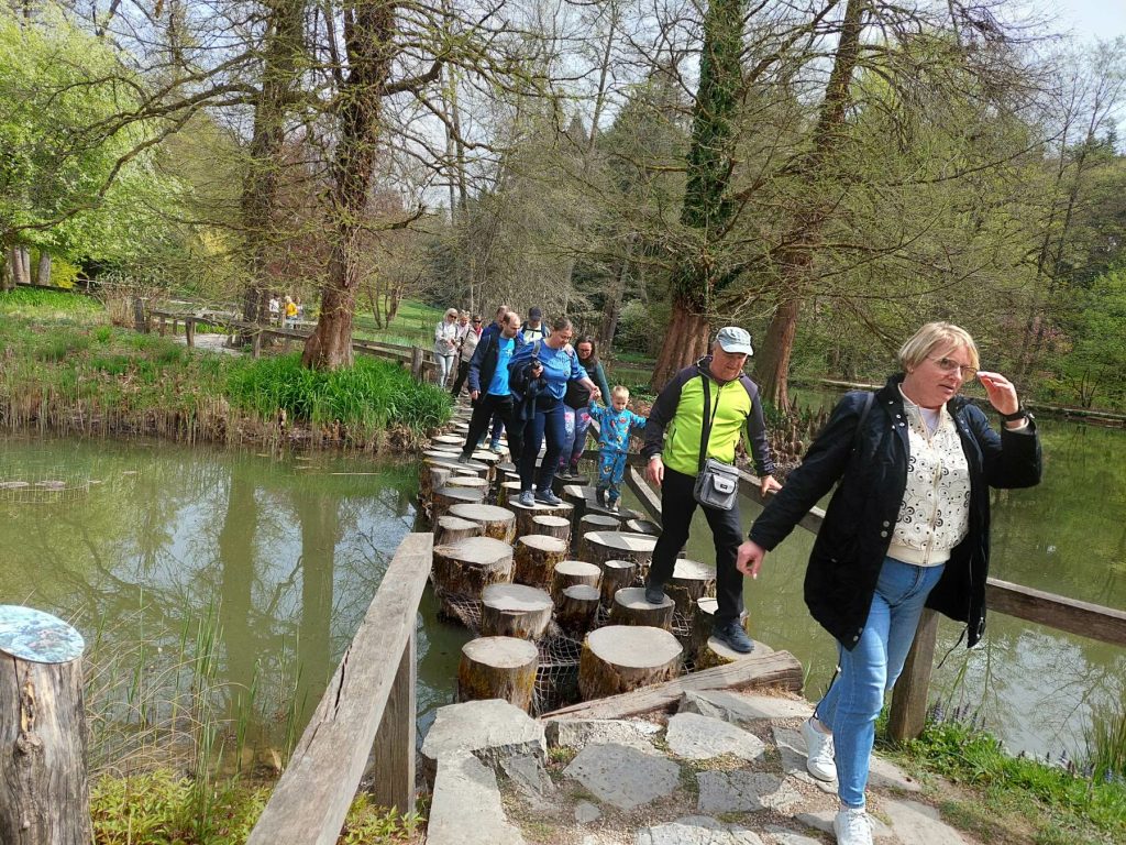 MDSS Ljubljana v Arboretumu Volčji Potok, 13.4.2026, ekipa med prečkanjem zanimivega lesenega mostu iz pokončnih odrezanih lesenih hlodov